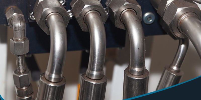 Marmon Keystone Close-up view of metal hydraulic tubes connected to fittings, highlighting Marmon/Keystone as your trusted metals distributor for JIC hydraulic tubing—welded J525 A214—available in stock and ready to ship for your supplychain needs.